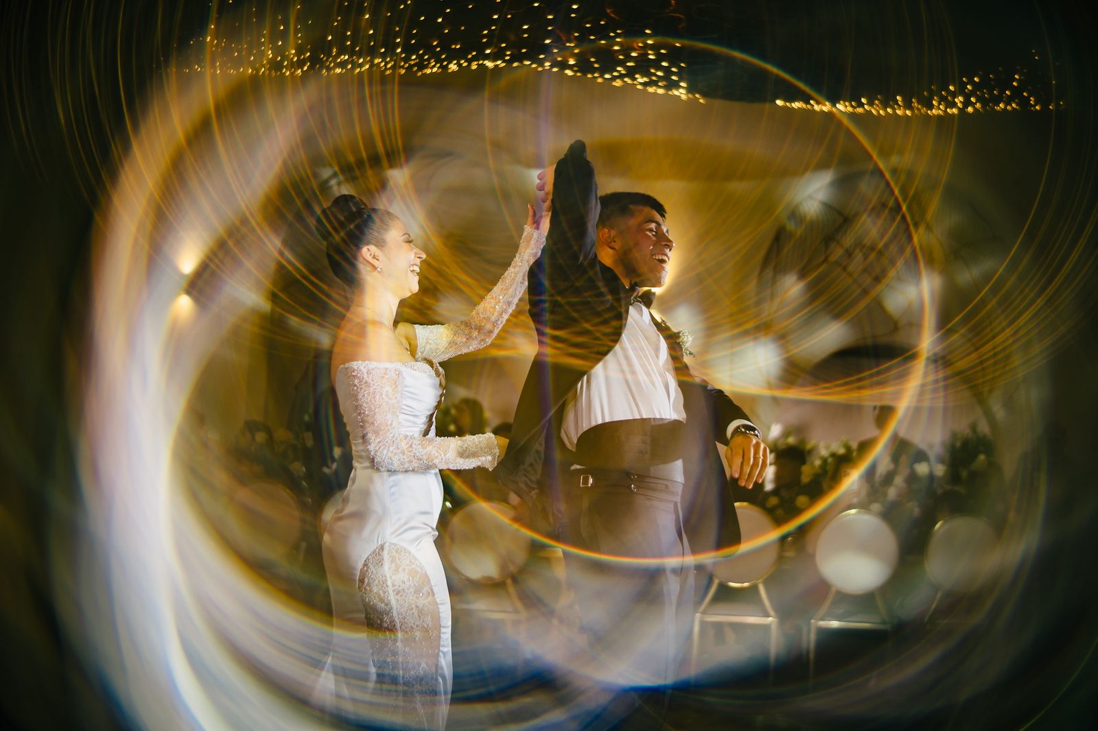 Primer baile de los novios entre estelas de luz doradas