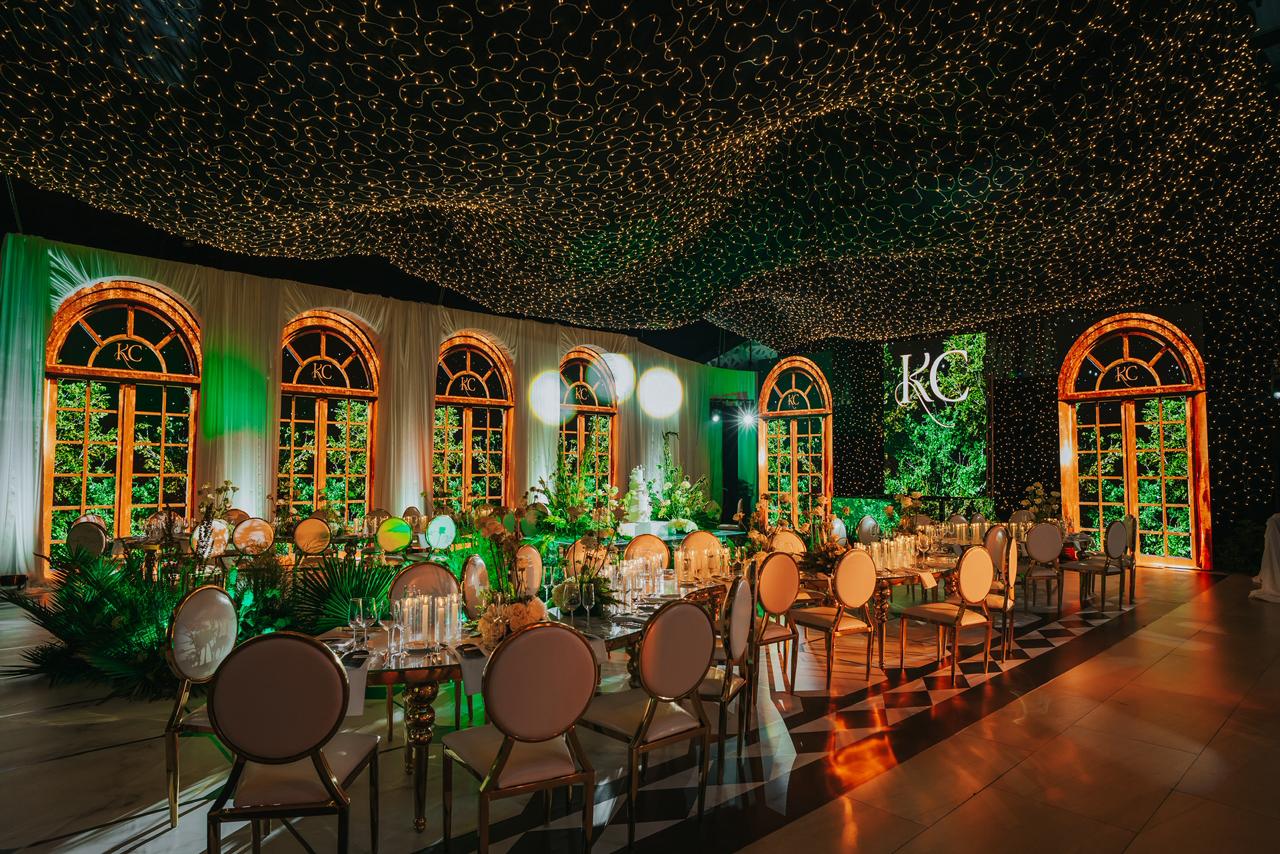 Salón de recepción con ventanales, monograma KC y cielo de luces