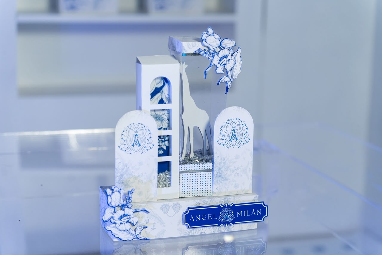Souvenir escultórico en blanco y azul con jirafa y monograma Ángel Milán