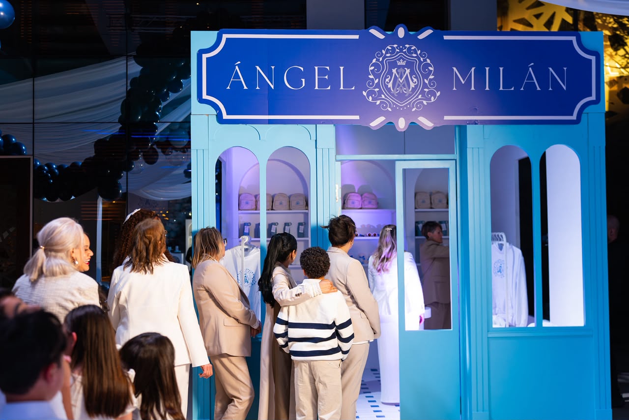 Fachada temática tipo boutique Ángel Milán con invitados recorriendo el montaje