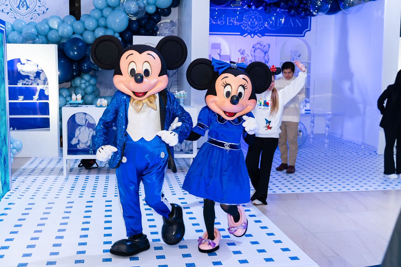 Personajes de Mickey y Minnie vestidos de azul en la ambientación del bautizo