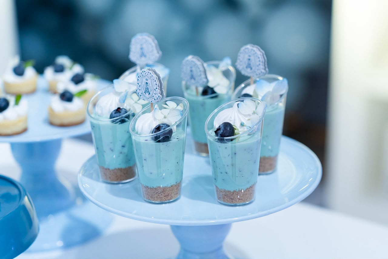 Postres individuales en tonos azules con arándanos y toppers del monograma